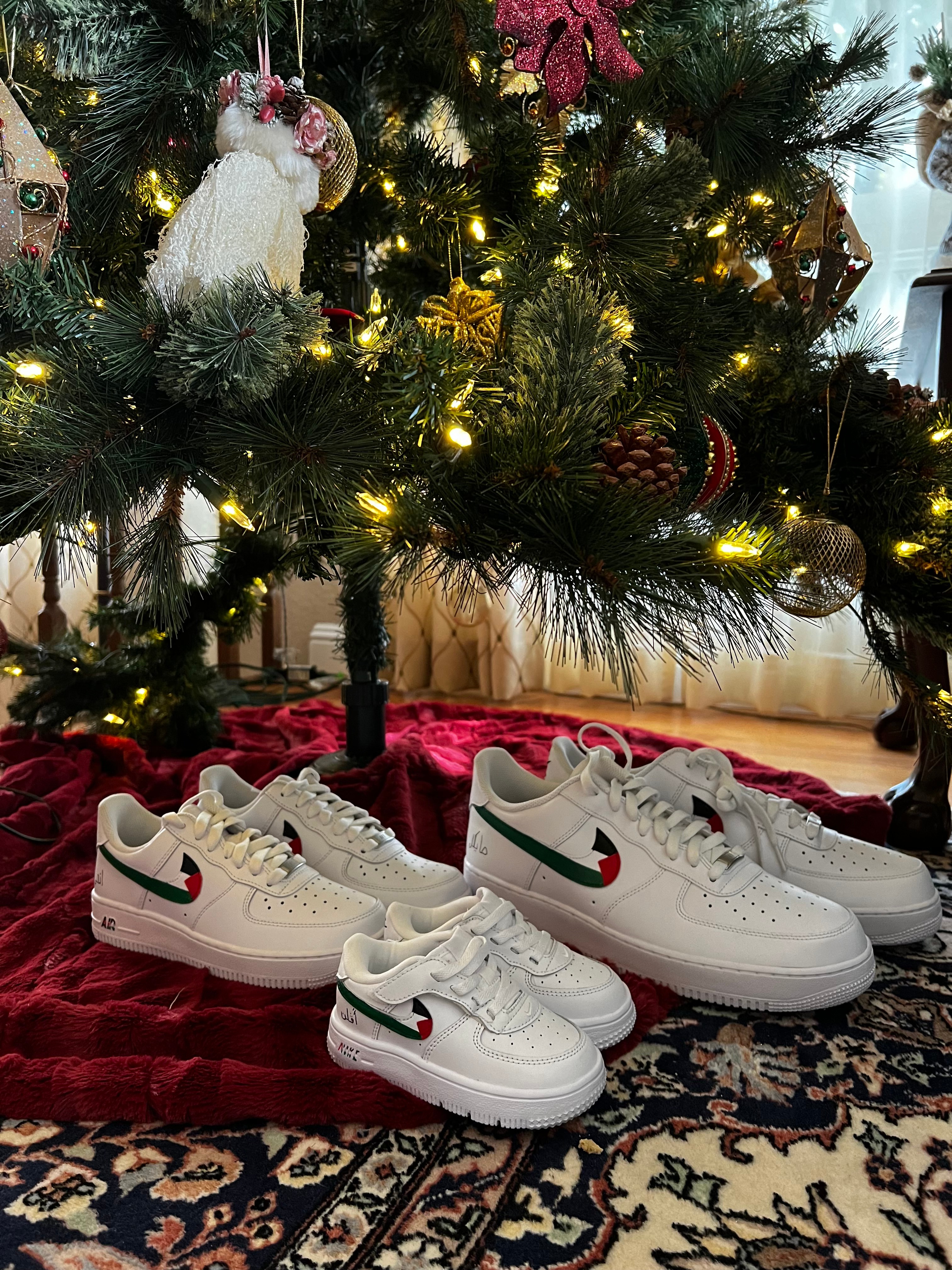 Family set of custom Palestinian flag Air Force 1s under Christmas tree, showing multiple sizes and holiday spirit