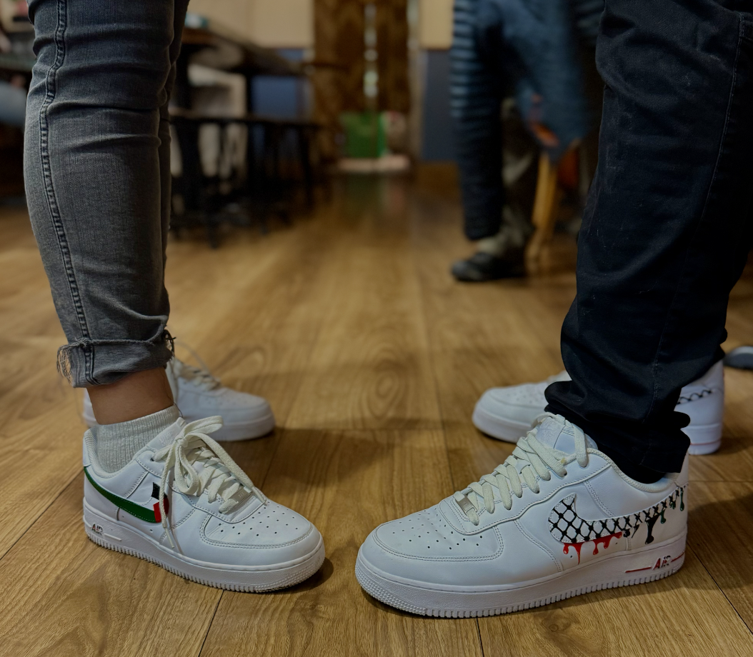 Custom painted Air Force 1s with Palestinian flag and Kuffiyeh patterns in studio setting